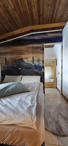 フォルガリダにあるLa Baita Residence 3.0の木製の天井が特徴のベッドルーム1室(ベッド2台付)