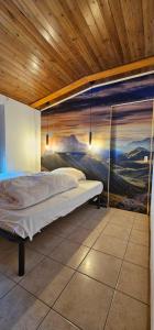 Bett in einem Zimmer mit Wandgemälde in der Unterkunft La Baita Residence 3.0 in Folgarida