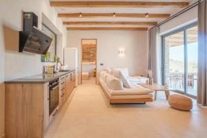 a kitchen and living room with a couch and a table at Villa Mirabilis in Ios Chora