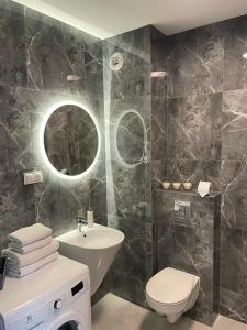 a bathroom with a sink toilet and a mirror at Premium Apartment Victoria 141 in Warsaw