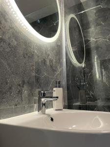 a bathroom with a white sink and a mirror at Premium Apartment Victoria 141 in Warsaw