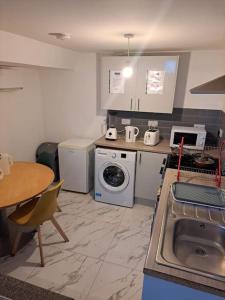 a kitchen with a sink and a washing machine at 1 Bedroom Flat Available in Oldham