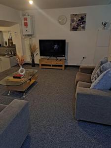 a living room with two couches and a flat screen tv at 1 Bedroom Flat Available in Oldham