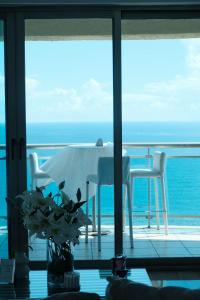 a table and chairs on a balcony with the ocean at Bello amanecer in Santo Domingo