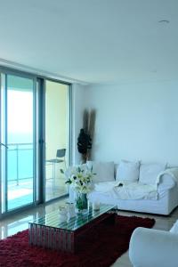 a living room with a white couch and a glass table at Bello amanecer in Santo Domingo