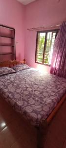 a bedroom with a bed and a window at Rivera Homestay in Udupi