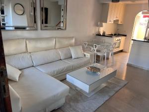 sala de estar con sofá blanco y mesa en Adosado en residencial, en Mijas Costa