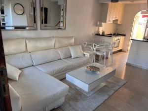 a living room with a white couch and a table at Adosado en residencial in Mijas Costa