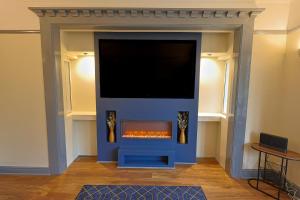 a fireplace with a tv on top of it at Waves of Memories Rhos on Sea in Llandrillo-yn-Rhôs
