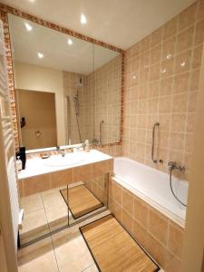 ein Badezimmer mit einer Badewanne, einem Waschbecken und einem Spiegel in der Unterkunft 2 Bebrooms Duplex in Cannes