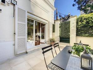a patio with a table and chairs and a window at 2 Bebrooms Duplex in Cannes