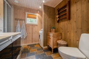 y baño con aseo y lavamanos. en Your Ideal Getaway Awaits in This Charming Cabin Retreat, en Nord Torpa