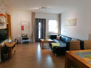 een woonkamer met een bank en een tafel bij Ferienwohnung am Reinhardswald -Buchenzweig- in Trendelburg