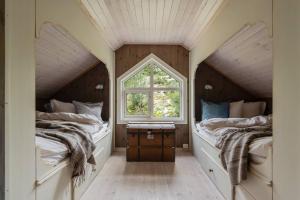two beds in a room with a window at Your Ideal Getaway Awaits in This Charming Cabin Retreat in Nord Torpa