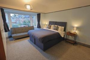 a bedroom with a bed and a couch and a window at Waves of Memories Rhos on Sea in Llandrillo-yn-Rhôs