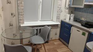 a small kitchen with a glass table and chairs at Loft apartment near city center on Peremogy Avenue 44 in Chernihiv