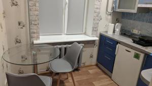 a small kitchen with a glass table and chairs at Cozy apartment near city center on Peremogy Avenue 44, bus and railway station nearby in Chernihiv