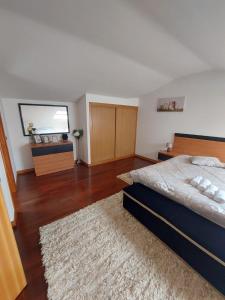 a large bedroom with a bed and a rug at duplex de luxo haut standing bord de plage avec piscine privée chauffée intérieurs in Esposende