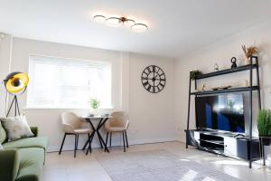 a living room with a tv and a table at Stylish 1 bed apartment with free parking in Cardiff
