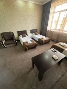 een woonkamer met 2 bedden en een salontafel bij Olympic Hotel in Gjoemri