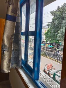 una ventana abierta con vistas a la calle en Nest Tales Backpacker Hostel en Khajurāho