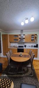 a kitchen with a table and chairs in a room at Apartman Jonjić in Kupres