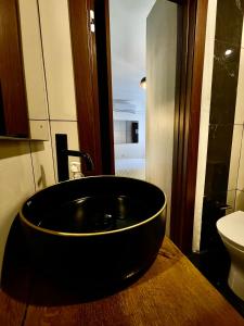 Łazienka z umywalką z czarną miską na drewnianym blacie w obiekcie Airport Accommodation Bedroom with your own private Bathroom Self Check In and Self Check Out Air-condition Included w mieście Mqabba