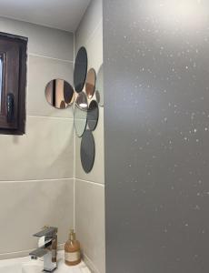 un bagno con lavandino e specchi sul muro di VILA MAGDA a Divčibare