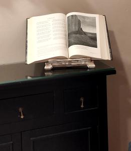 un libro aperto, seduto sopra un cassettone. di Dante Experience Apartment a Firenze