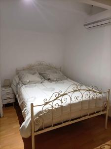 um quarto com uma cama com lençóis brancos e uma mesa de cabeceira em Le 7 em Servian