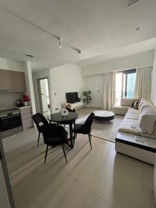 a living room with a couch and a table and chairs at 2 Bedrooms Apartment Burj khalifa and fountain view in Dubai