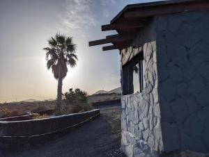 un edificio de piedra con una palmera en el fondo en Buena Vista, Sea View Apto de Oasis Vasiliko , La Asomada, en Tías 28 fotos más
