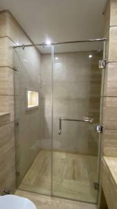 um chuveiro com uma porta de vidro na casa de banho em صن سيتي em Cairo