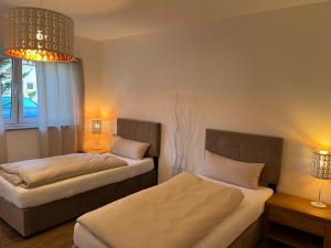 勒文斯坦的住宿－Ferienwohnung Gergert Nr.2，一间卧室配有两张床和吊灯。