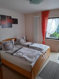 a bedroom with two beds and a window at B&B Pension Winzerhaus Zell-Mosel in Zell an der Mosel