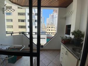 Il comprend une cuisine et un balcon offrant une vue sur la ville. dans l'établissement Apartamento centro de BC, à Balneário Camboriú