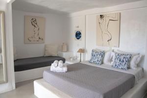 a white bedroom with two beds and a couch at Anemoi Resort in Naousa