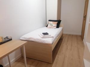 a small bedroom with a bed and a desk at Apartamenty Jaskółcza in Bydgoszcz