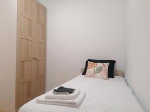 a bedroom with a bed with a pillow and a closet at Apartamenty Jaskółcza in Bydgoszcz