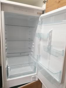 an empty refrigerator with its door open in a kitchen at Apartamenty Jaskółcza in Bydgoszcz
