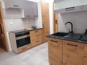 a kitchen with a sink and a stove at Apartamenty Jaskółcza in Bydgoszcz