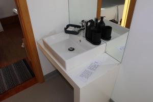 un lavandino bianco con bottiglie sopra di Pensão Central ad Aveiro Altre 20 foto