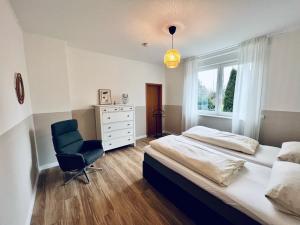 ヴンストルフにあるFerienwohnungen Maedchenのベッドルーム1室(ベッド1台、椅子、窓付)