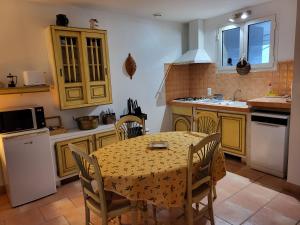 a kitchen with a table and chairs and a sink at La Chouette de Camargue in Aigues-Mortes