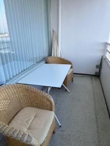 stół i 2 krzesła w pokoju z oknem w obiekcie ButschisBude w mieście Sierksdorf