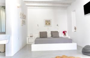 1 dormitorio con 1 cama en una habitación blanca en Anemoi Resort en Náousa