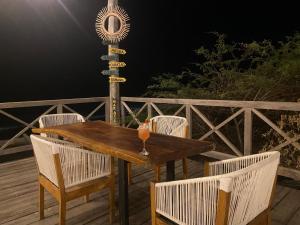 Camarones的住宿－Mar Azul - Playa y Turismo，夜间甲板上的木桌和椅子