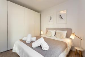 エストリルにあるSeaside Serenity in Estorilのタオルが敷かれたベッドのある寝室