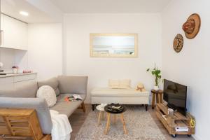 エストリルにあるSeaside Serenity in Estorilのソファとテレビのあるリビングルーム