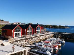 a red house with boats docked at a marina at High standard Lodge Ballstad in Ballstad